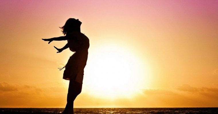 A silhouette of a woman on a backdrop of a sunset